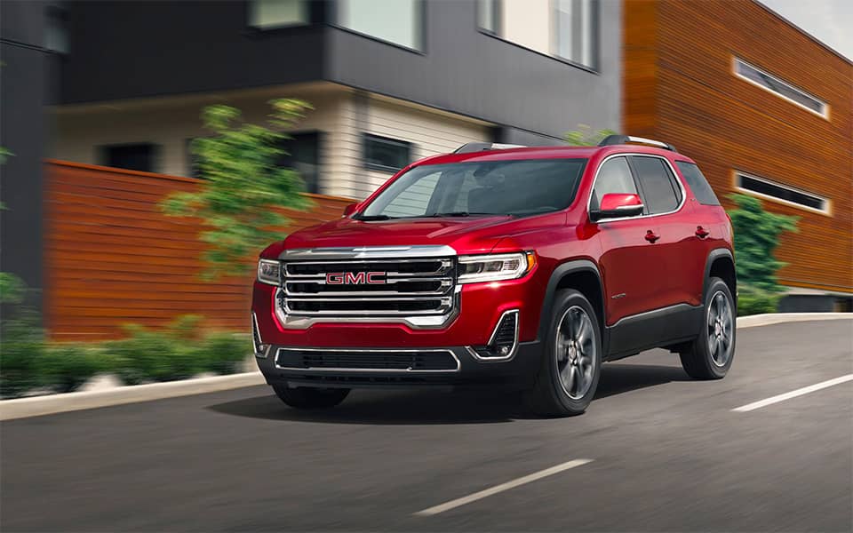 front angled view of a red Acadia cruising down a road